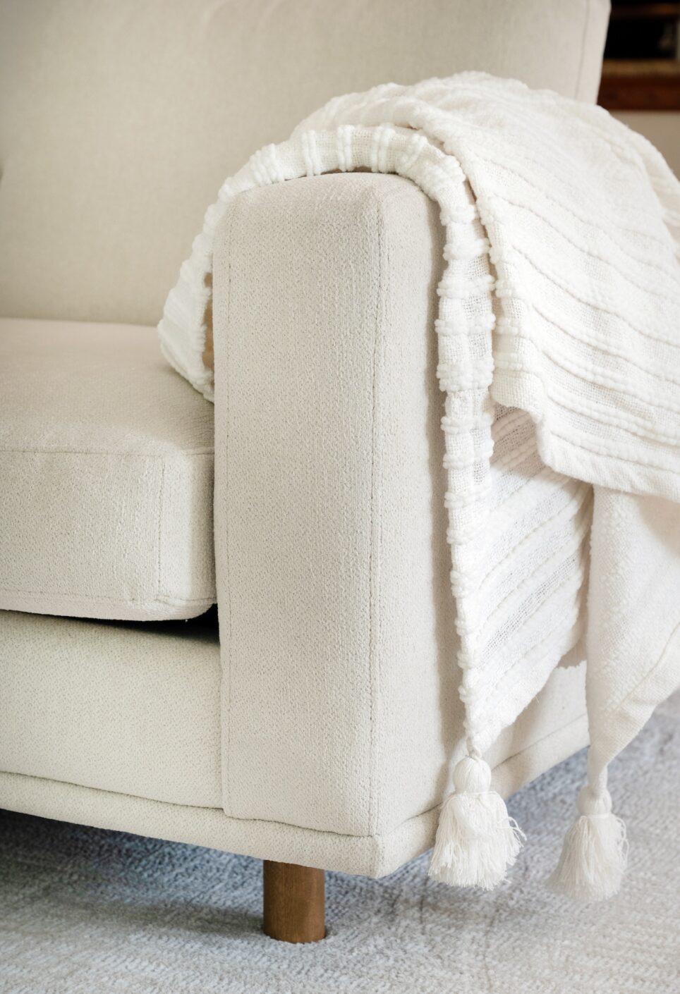Cream Sofa With White Accent Blanket